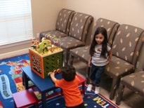 Two children playing together in the waiting room