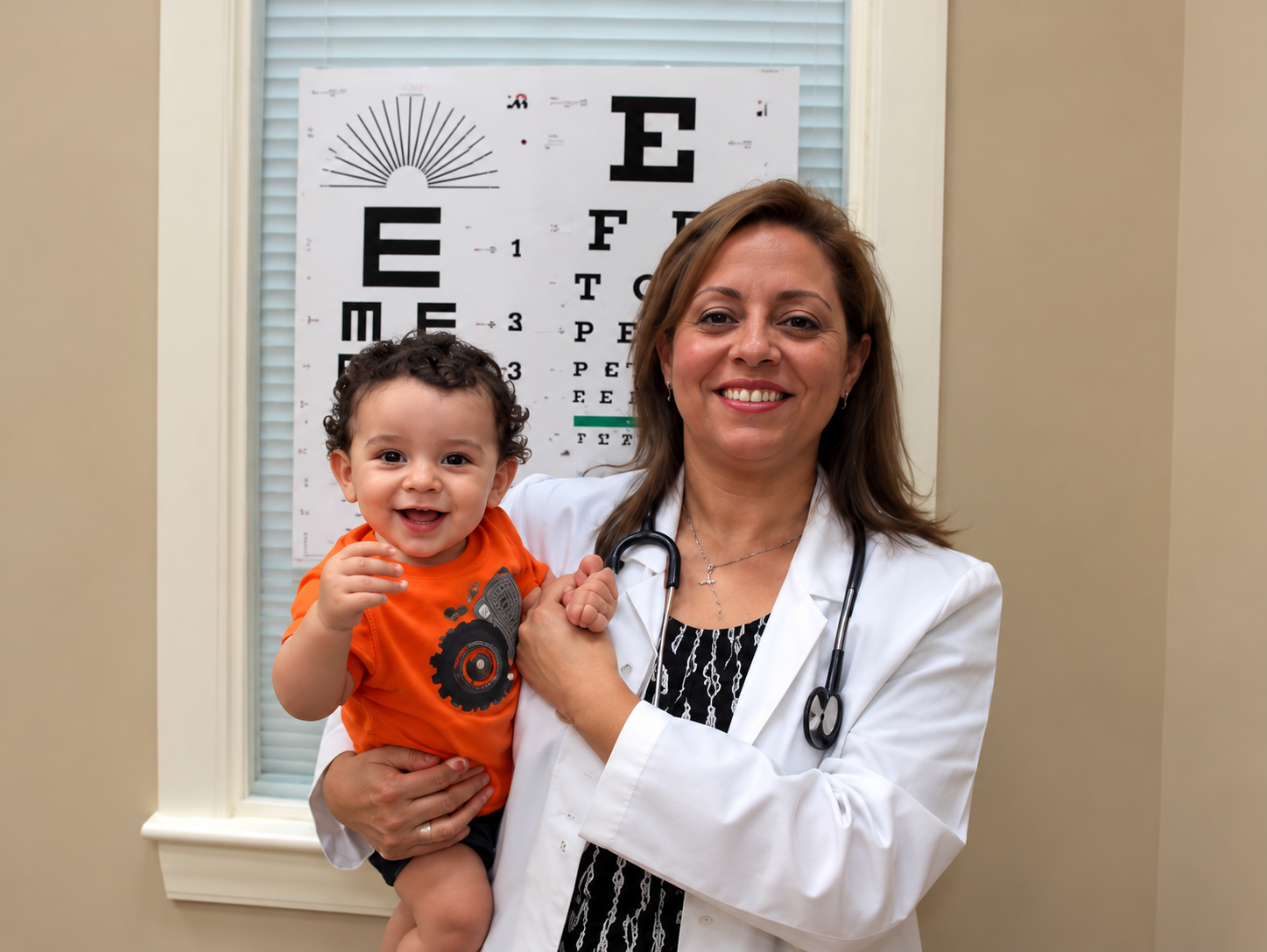 Dr. Attia holding a baby patient in the exam room