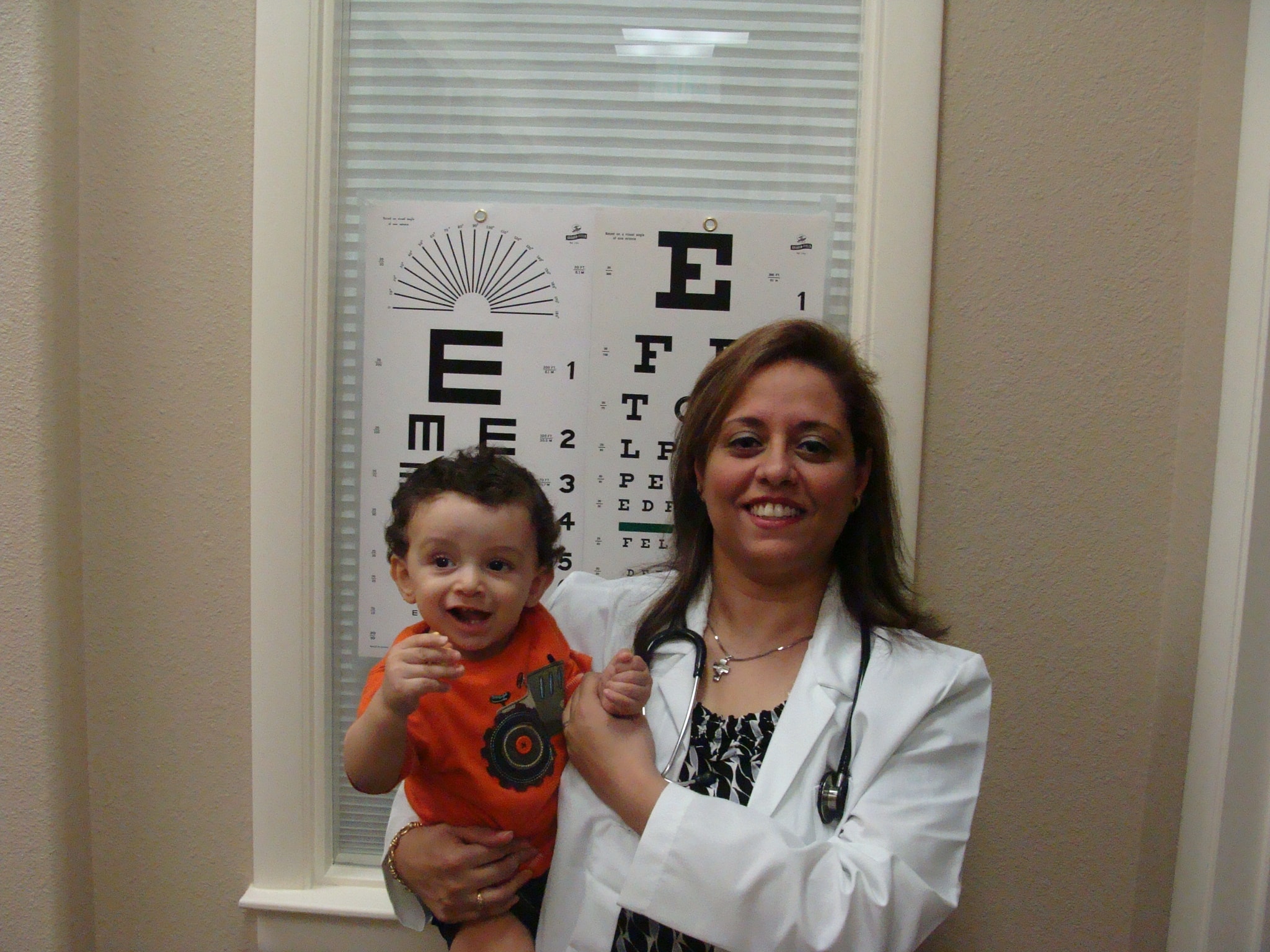 Dr. Attia holding a baby patient in the exam room