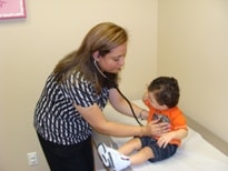 Staff member examining a young child with a stethoscope